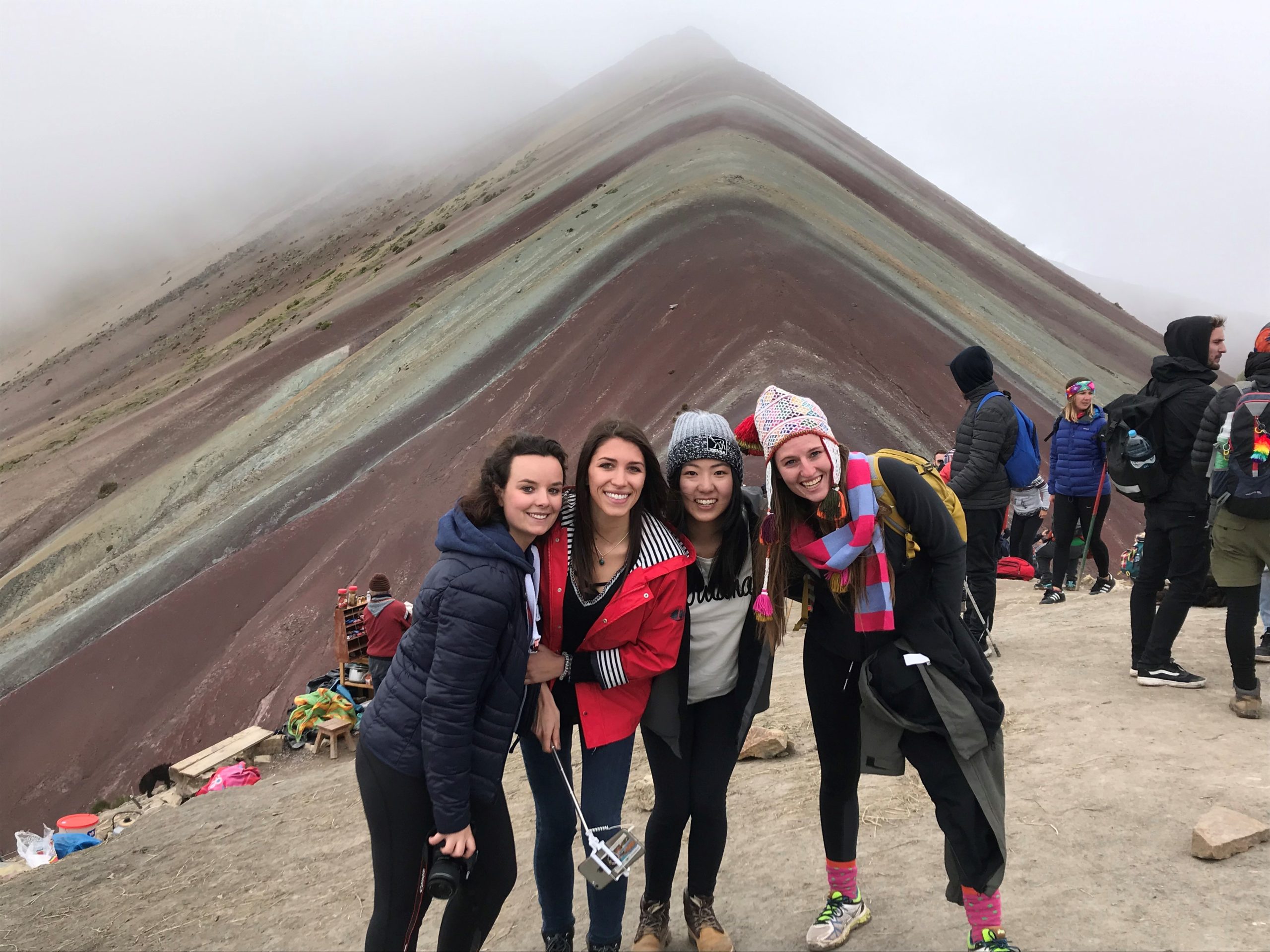 4 Friends together at the top of Rainbow Mountain in Peru