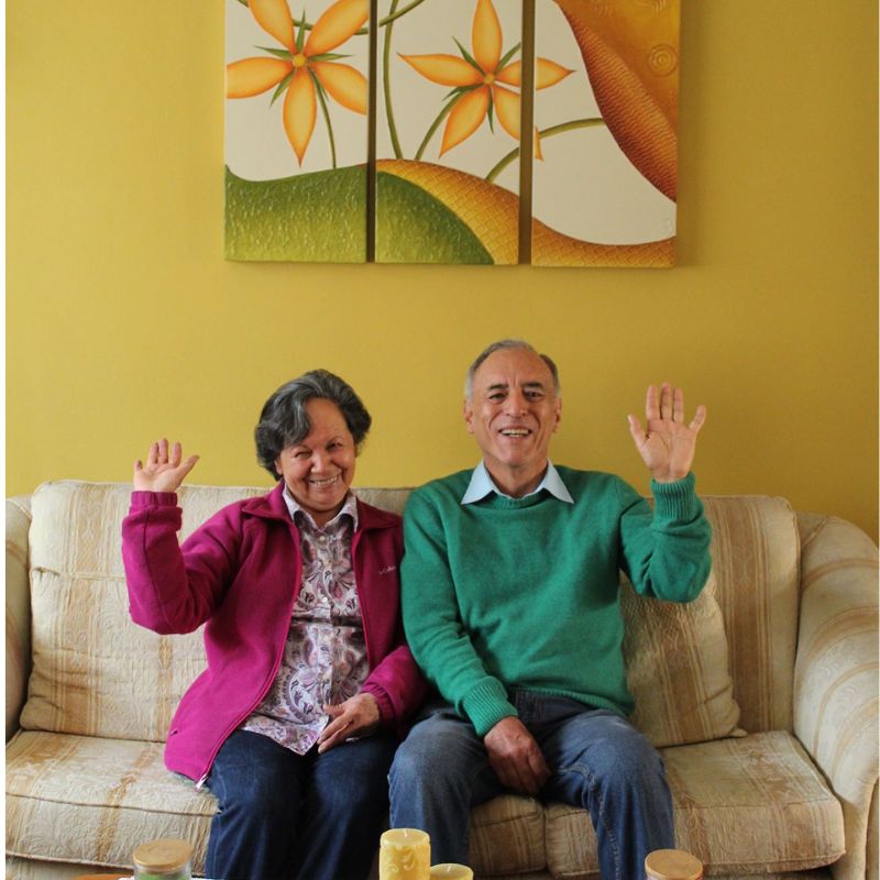 A homestay family in cusco wave from the couch of their beautiful home